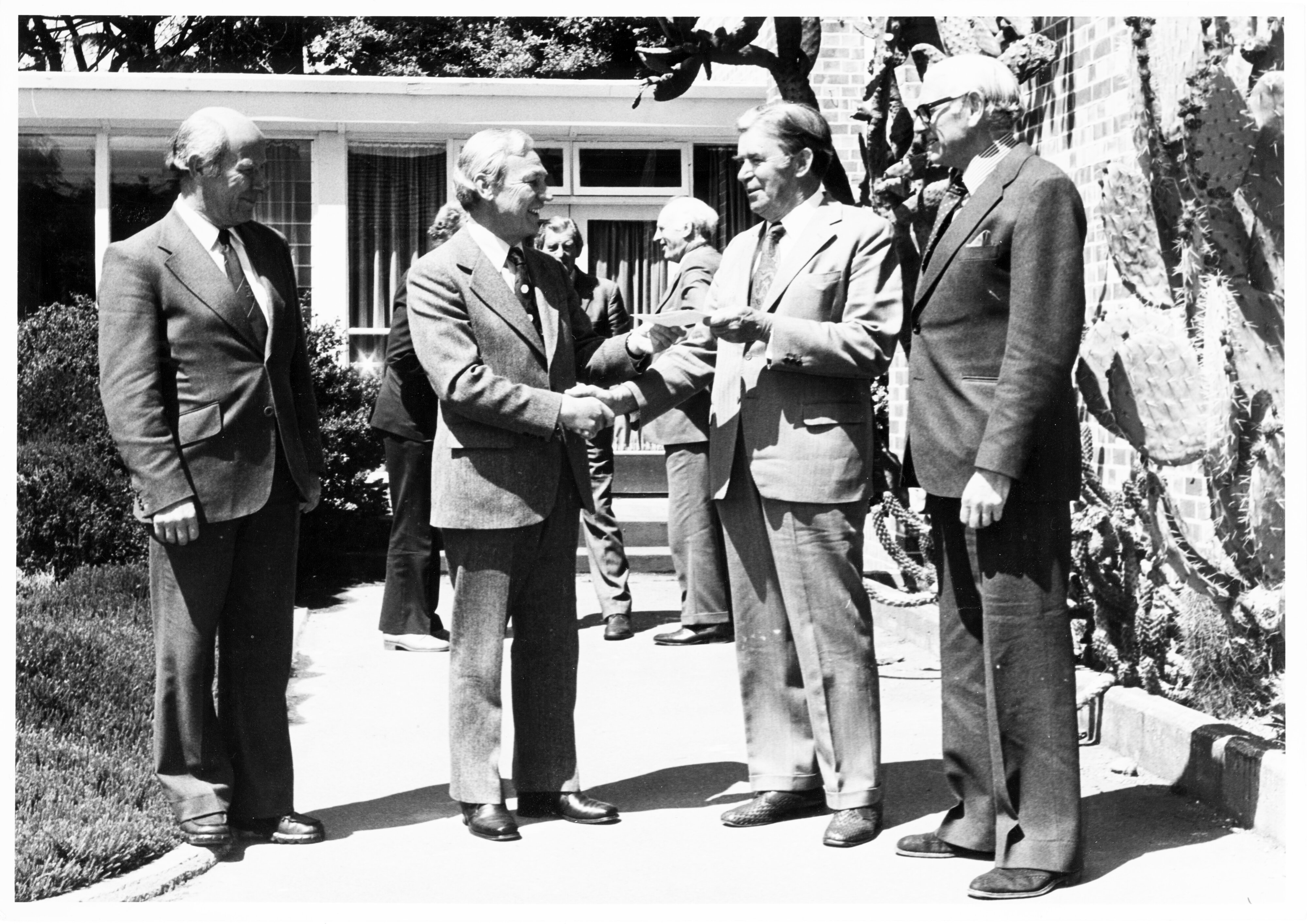 c1960-c1970s Council members outside Refectory Building next to the cactus garden