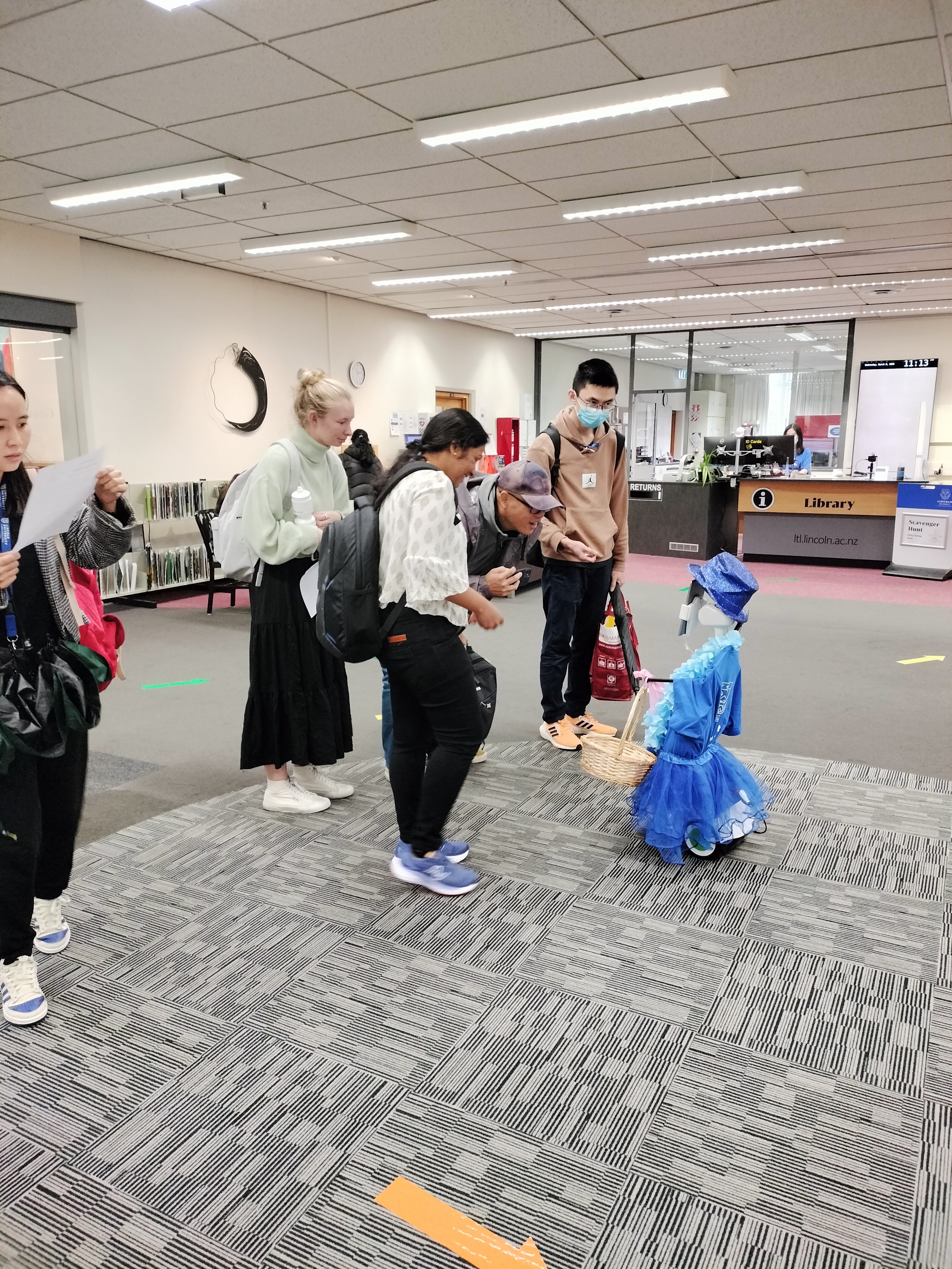 Students talking to Ivey the Robot