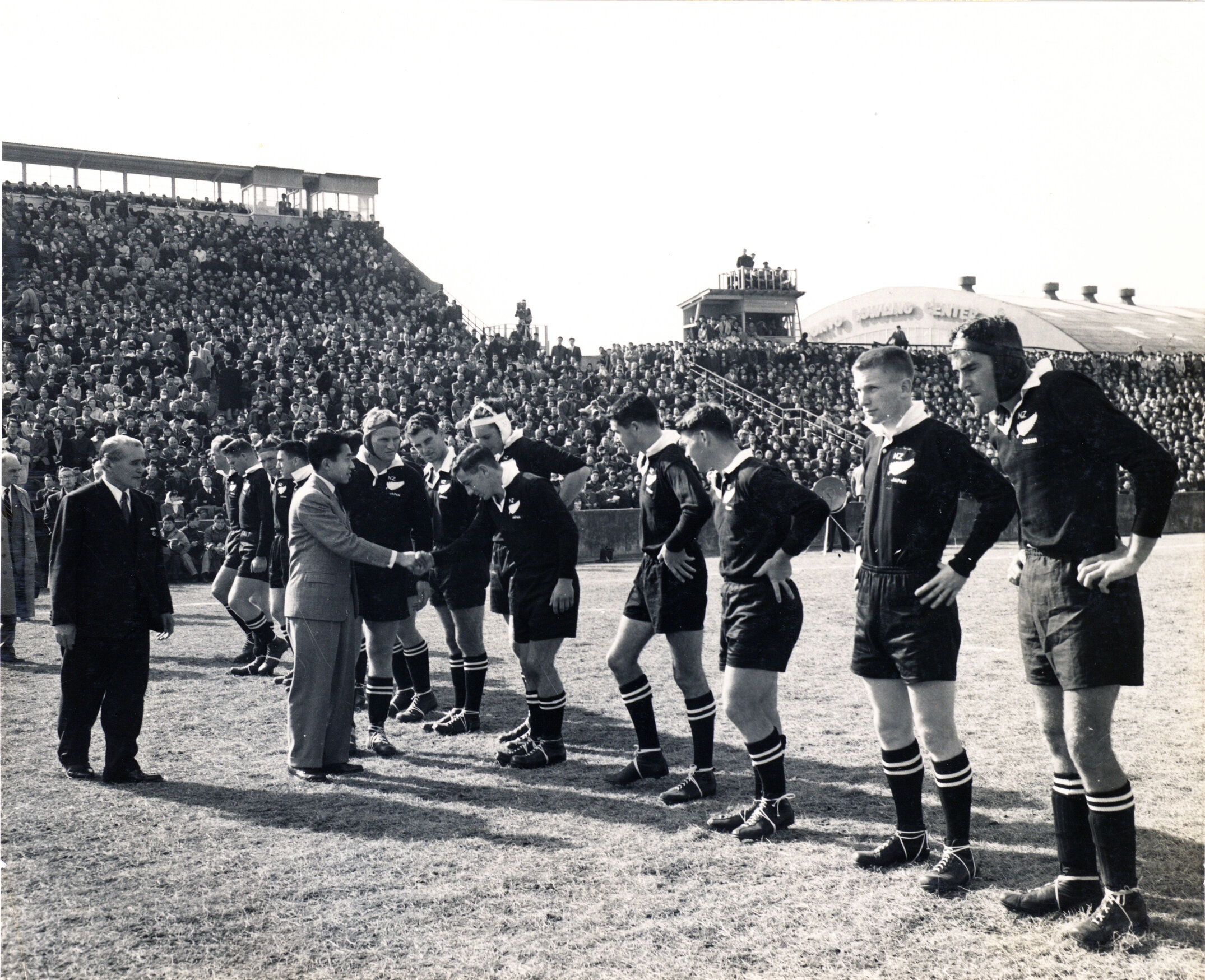Members of the New Zealand All Blacks shake hands with Crown Prince Akihito before their exhibition match at the Tokyo Dome Sports Centre, 1958