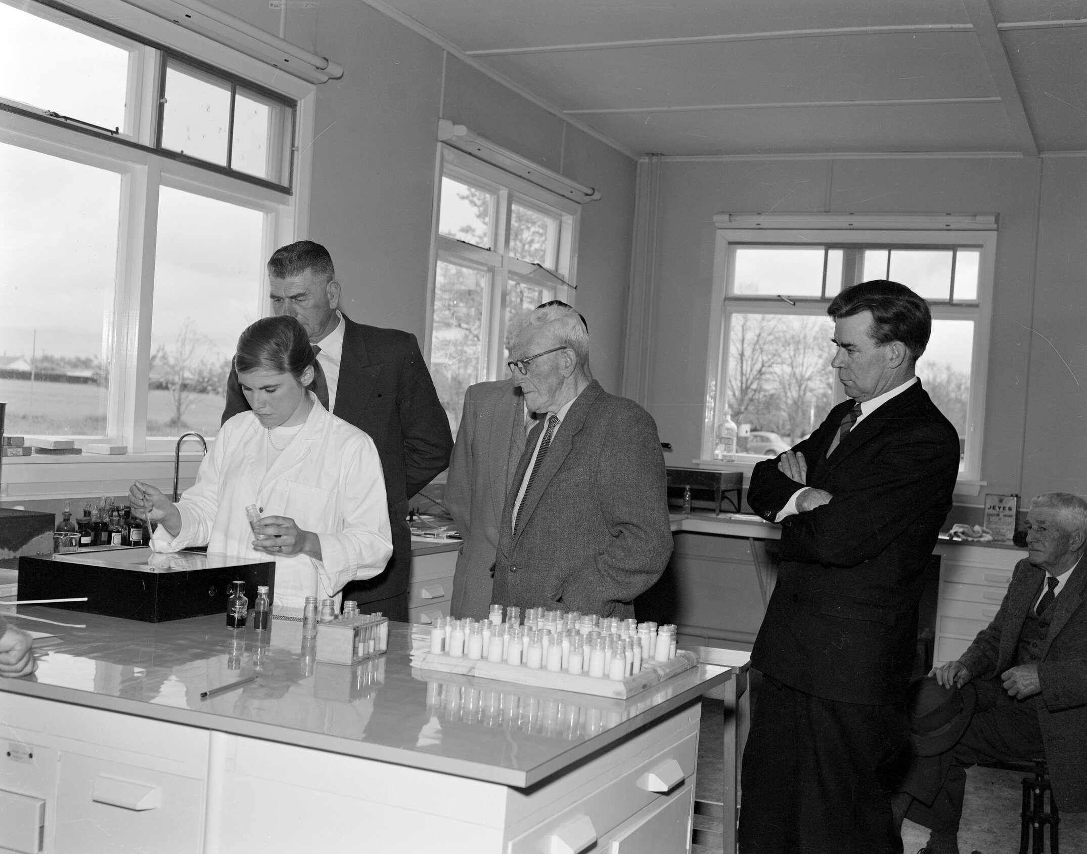Members of the Board watching the whey agglutination test for Brucellosi being carried out (Blackmore Neg 5145)