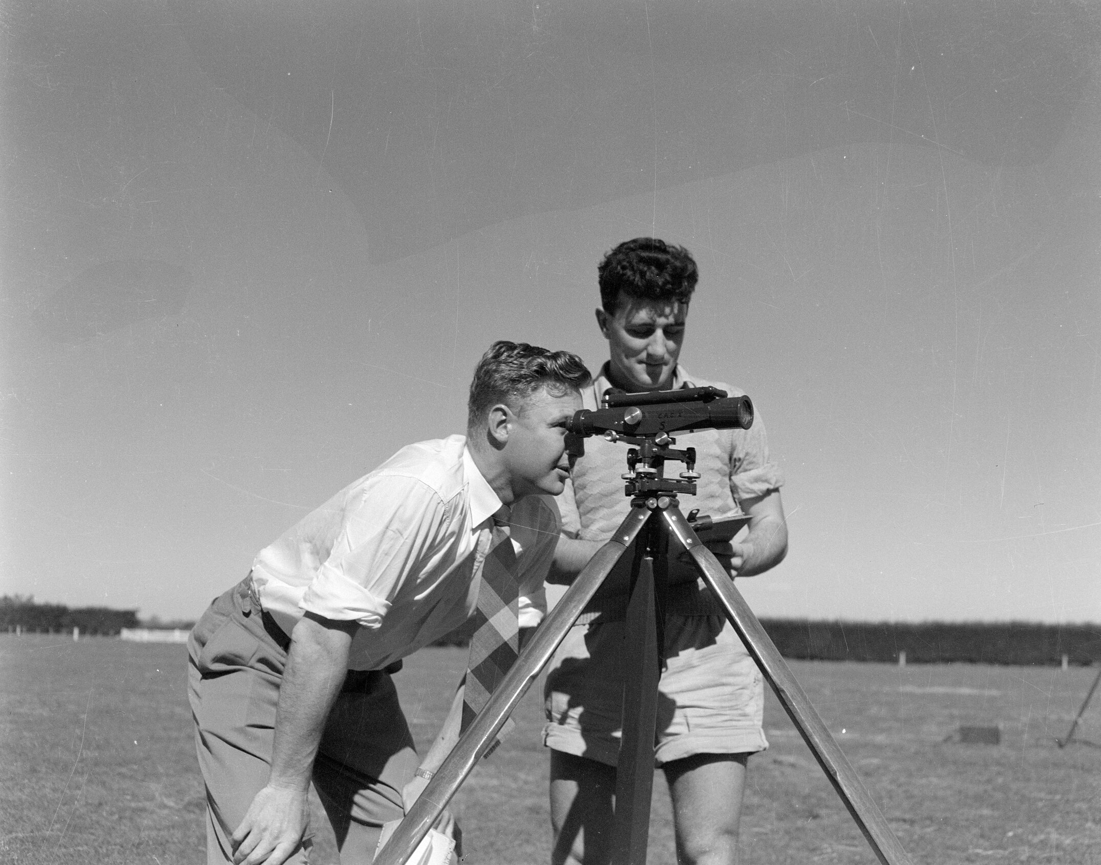 Students carrying out surveying fieldwork with theodolite (Blackmore Neg 5183)