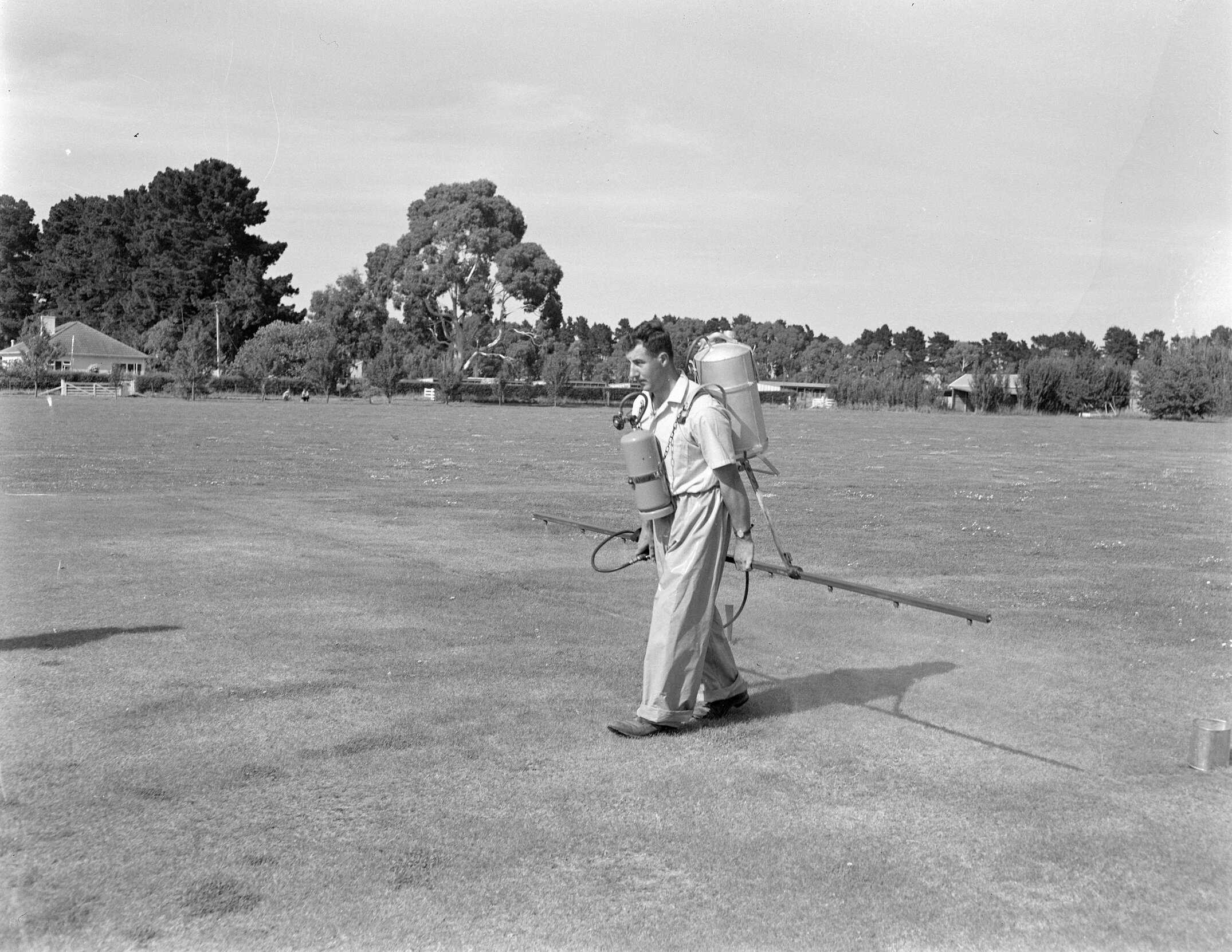 Manual field spraying on Lincoln College grounds (Blackmore Neg 5186)