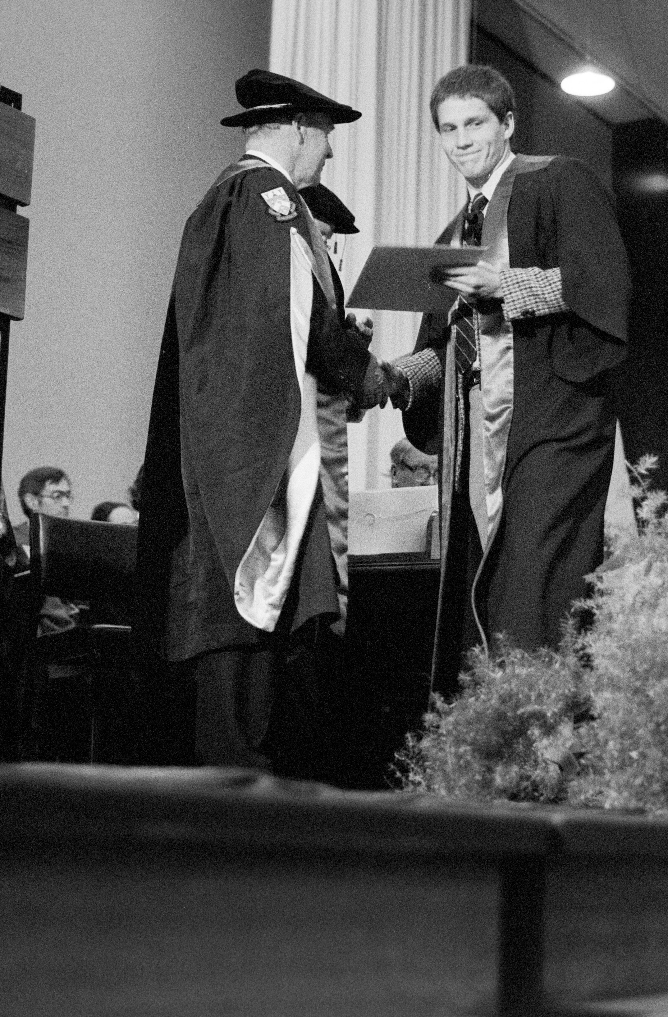 Graduate Receiving Degree Certificate from Sidney M. Hurst at the Lincoln College Graduation Ceremony, Gillespie Hall, 04 May 1984 02