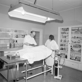 G.G.Thompson uses the operating theatre in the new veterinary block,1957 (Blackmore Neg 5175)
