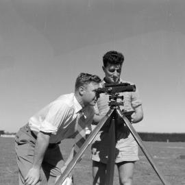 Students carrying out surveying fieldwork with theodolite (Blackmore Neg 5183)