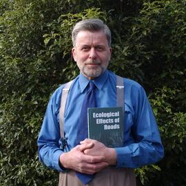 Professor Ian Spellerberg holding a copy of Ecological Effects of Roads, 23 August 2002.
