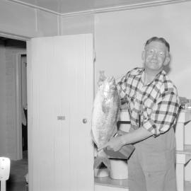 Ron Blackmore holding a large fish indoors, circa 1962(Blackmore Neg 5228)