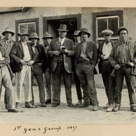 Canterbury Agricultural College 1st year student group and farm manager G. A. Willis in front of a College farm building, 1st year group 1917