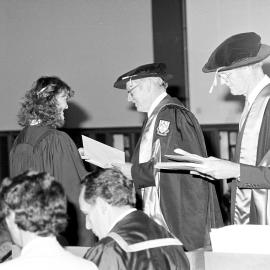 Sidney M. Hurst, Chairman of the College Council Presenting a Degree Certificate at Graduation Ceremony, 1981 01