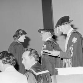 Sidney M. Hurst, Chairman of the College Council Presenting a Degree Certificate at Graduation Ceremony, 1981 02