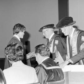 Sidney M. Hurst, Chairman of the College Council Presenting a Degree Certificate at Graduation Ceremony, 1981 03