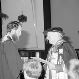 Sidney M. Hurst, Chairman of the College Council Presenting a Degree Certificate at Graduation Ceremony, 1985 03
