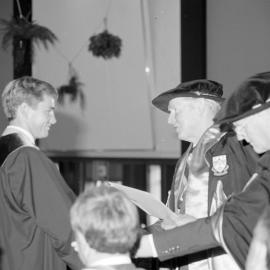 Sidney M. Hurst, Chairman of the College Council Presenting a Degree Certificate at Graduation Ceremony, 1985 02