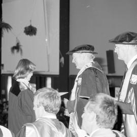 Sidney M. Hurst, Chairman of the College Council Presenting a Degree Certificate at Graduation Ceremony, 1985 01