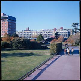 Students are walking towards the Refectory, Geoge Forbes and Hilgendorf buildins in the background, 1976