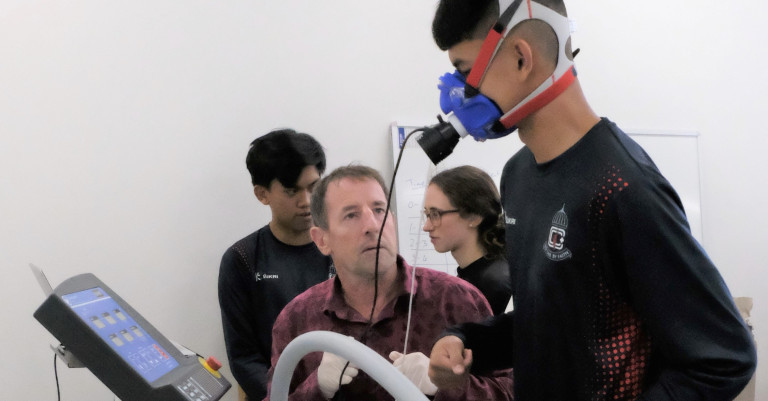 Image: Professor Mike Hamlin puts a visitor to the lab through testing.